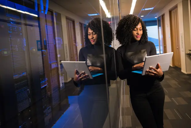An IT professional with a laptop in a server room
